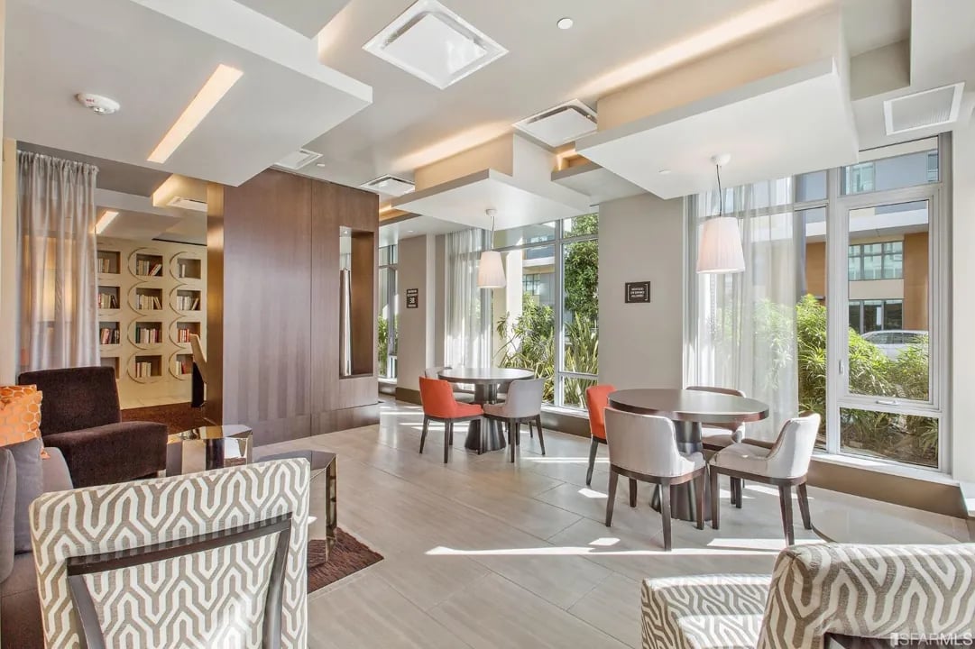 Arden Residences sophisticated resident clubroom with multiple seating areas, dining spaces, geometric patterned chairs, and panoramic windows in Mission Bay San Francisco