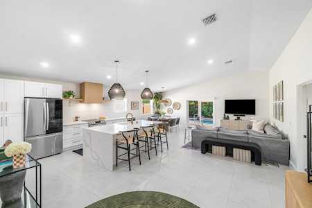 Open-plan kitchen and living room with a large island and gray sectional sofa.