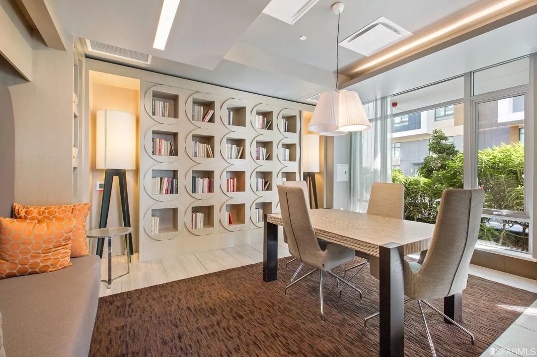 Arden Residences stylish study room with hexagonal built-in bookcase, work table, modern chairs, and floor-to-ceiling windows in Mission Bay
