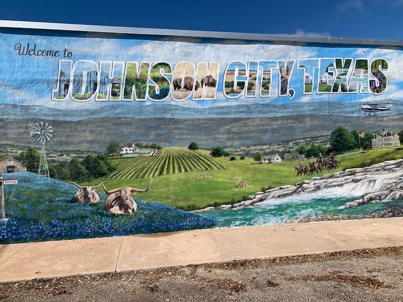 Johnson City, Texas welcome mural depicting a Hill Country landscape with bluebonnets and longhorns.