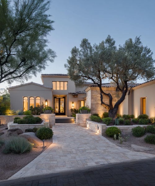 Modern luxury home in Tucson, Arizona, situated on over an acre of land with a long stone walkway and desert landscaping.