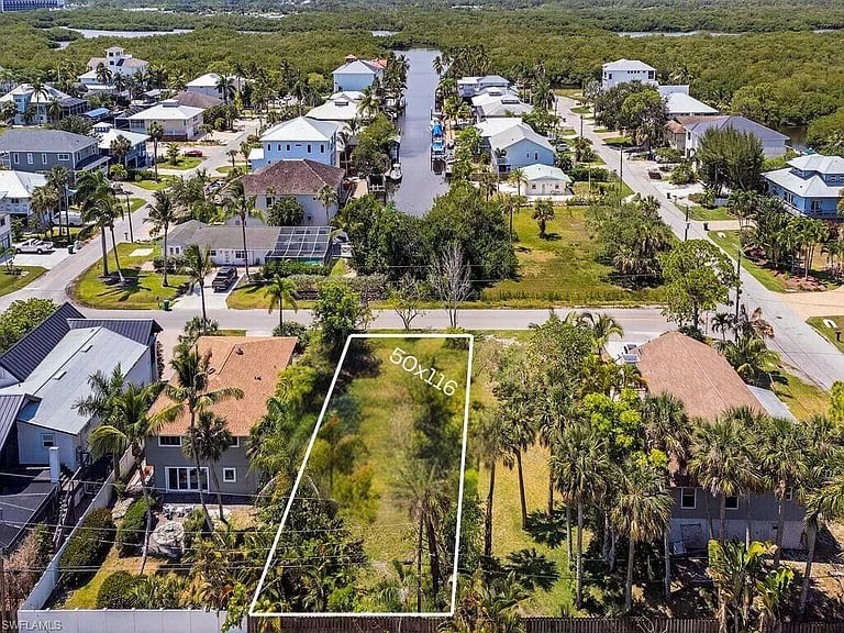 Aerial view of a vacant lot marked 50x110, with homes and a canal nearby.