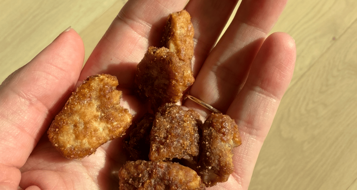 Golden-brown fried food pieces resting in an open palm.
