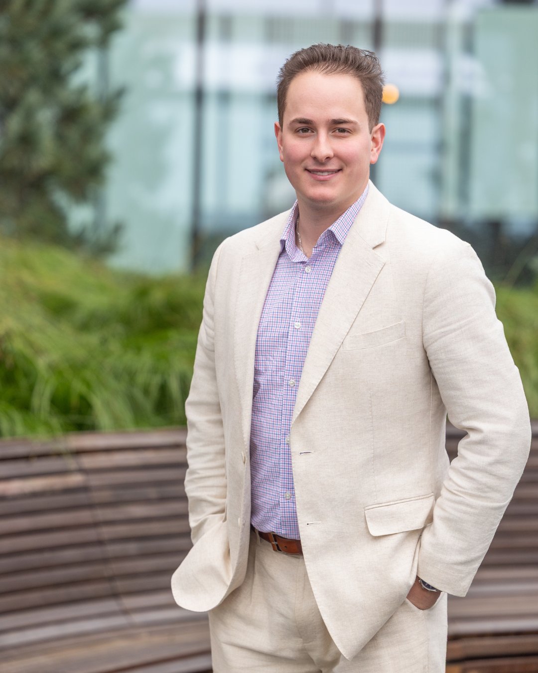 Michael Morgan, Eastside luxury real estate broker, smiling outdoors in a cream blazer and lavender check shirt.