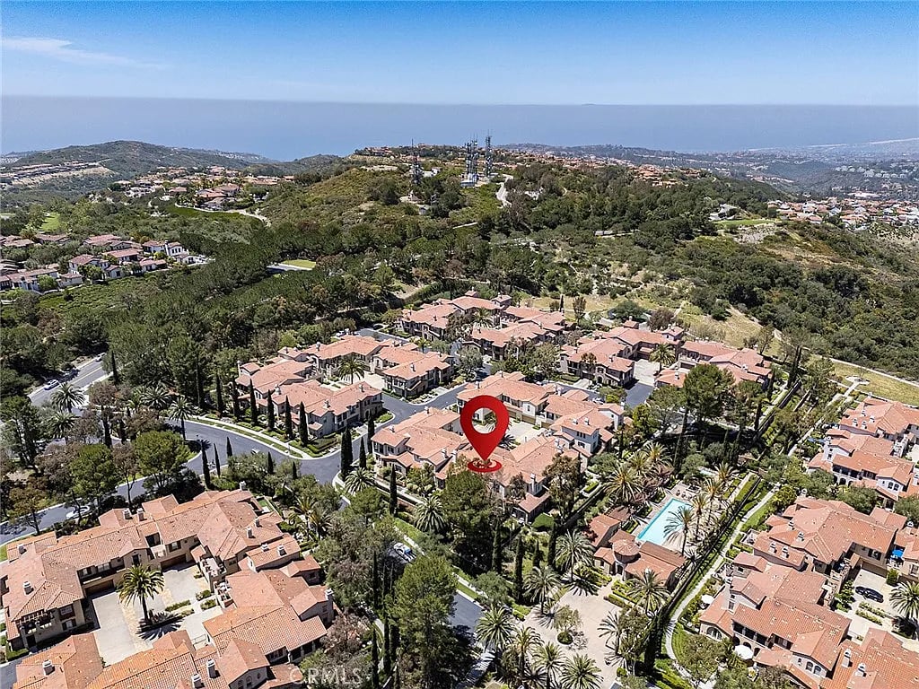 Aerial view of 23 Altino marked in a coastal neighborhood, with the ocean in the distance.
