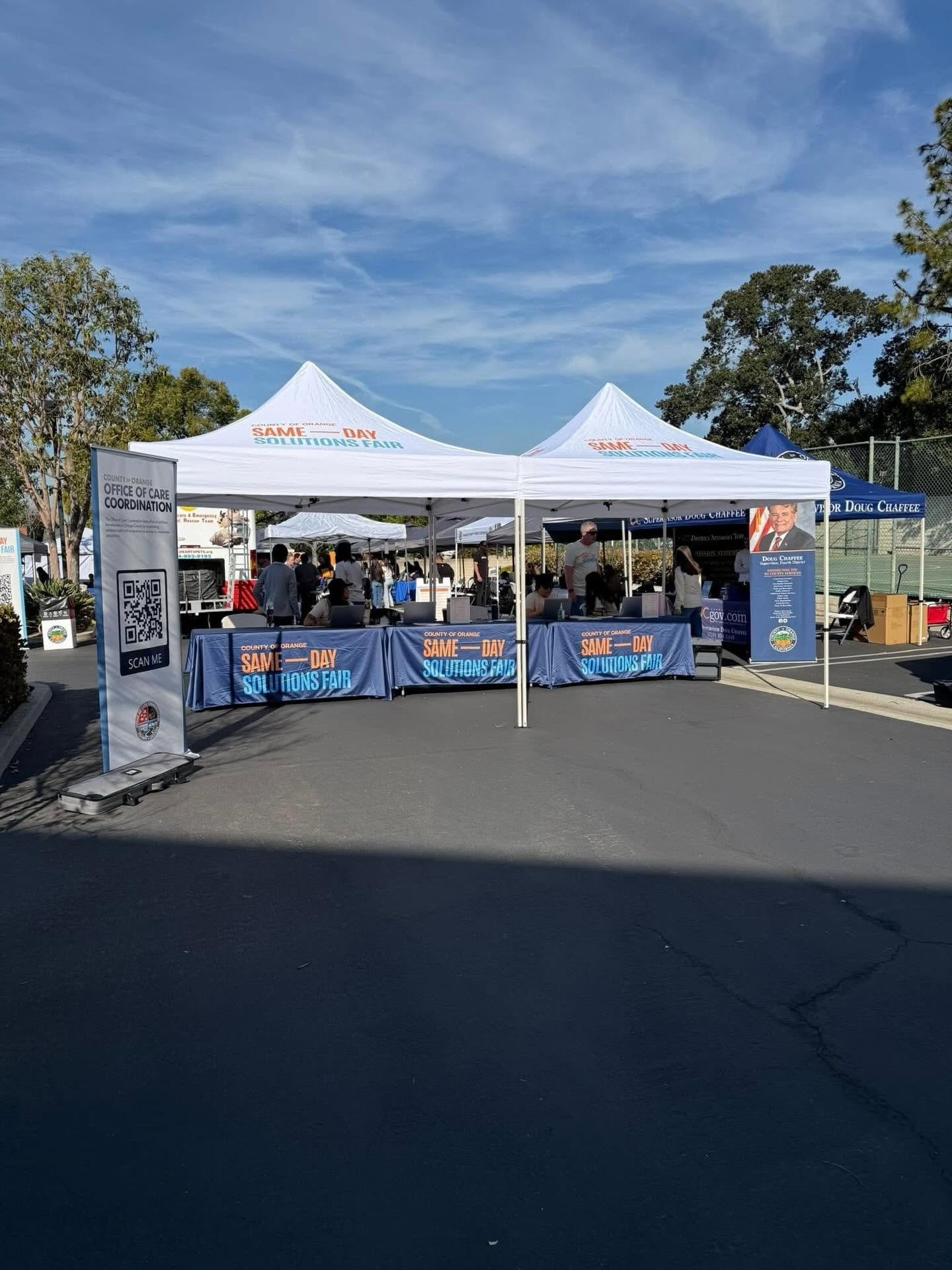 County of Orange Same Day Solutions Fair booths and tents with attendees outdoors.
