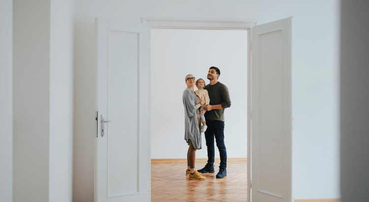 A man and woman standing together in an open doorway, engaged in conversation or enjoying the view outside.