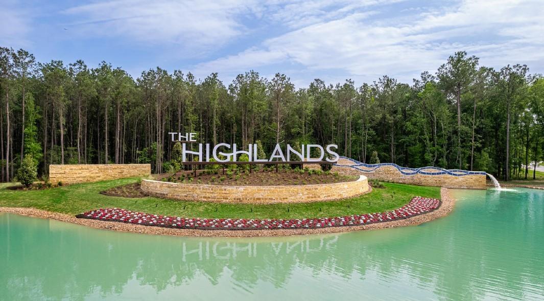 The Highlands community entrance sign beside a landscaped pond.