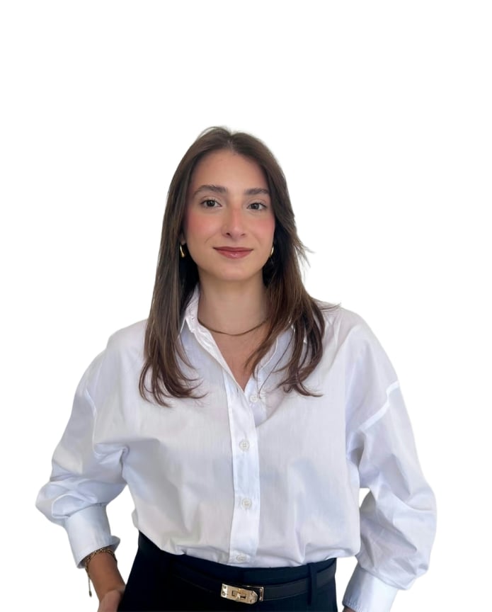 Briana Marrero wearing a white button-down shirt and dark trousers.