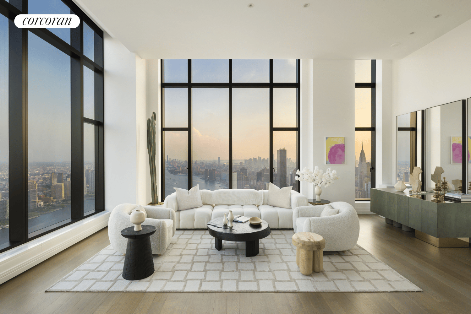 High-rise living room with floor-to-ceiling windows overlooking the Manhattan skyline and river at golden hour.