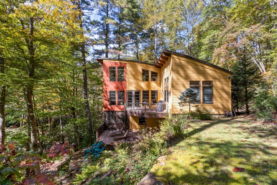 Craftsman-style home with wood siding and a deck surrounded by fall trees at 187 Big Buck Road, Highlands NC