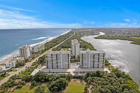 Coastal condominium buildings between the ocean and a broad waterway, seen from above.