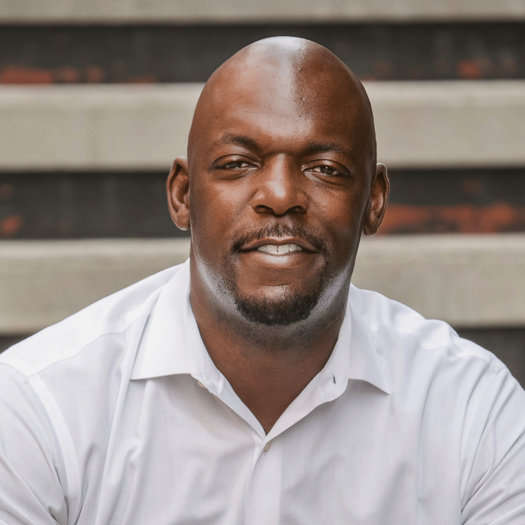 Tim Lewis in a white collared shirt, photographed from the chest up.
