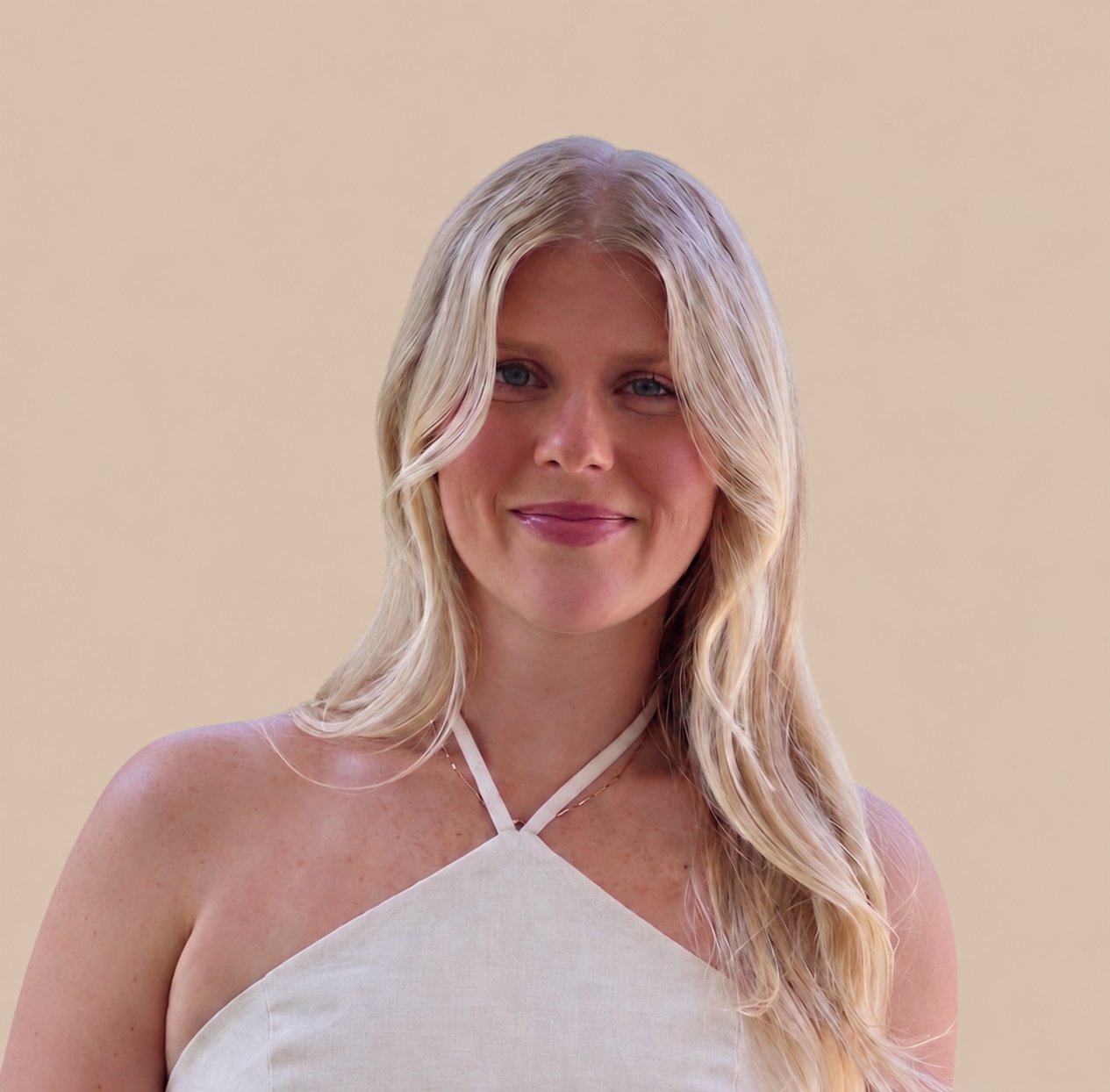 Haley Jenness smiling in a white halter top, with long blonde hair.
