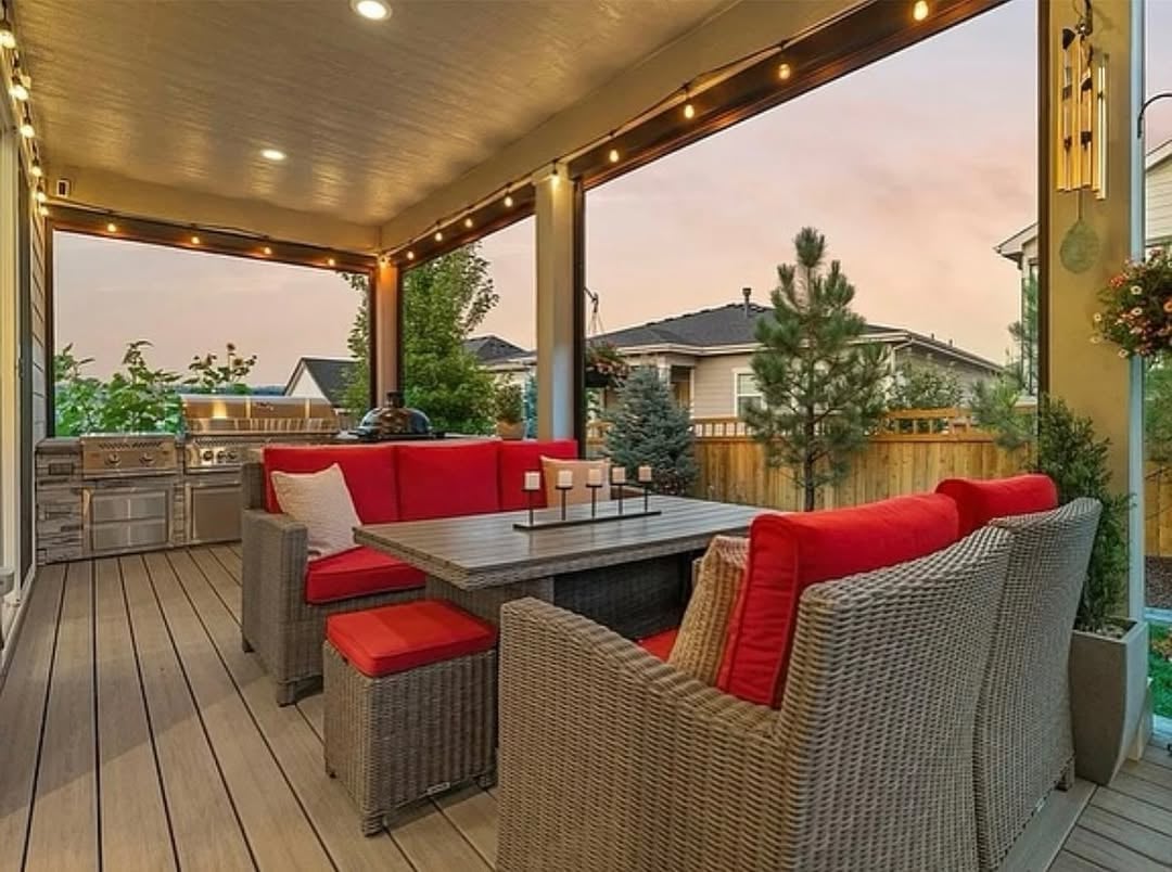 Outdoor living space at 2896 Keepsake Way in Castle Rock, Colorado, featuring a covered deck with string lights, built-in grill station, sunset views, and seating area—highlighting Colorado’s outdoor lifestyle in The Meadows community.