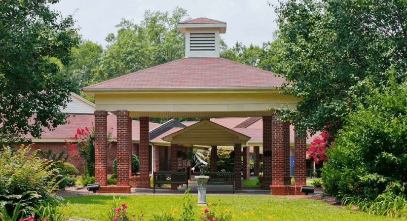 Senior living entrance with a red-brick porte cochere and landscaped grounds.