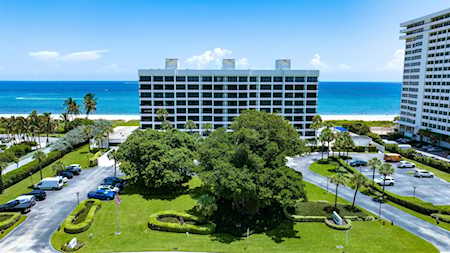 Beachfront condominiums with landscaped grounds and parking beside the Atlantic Ocean.