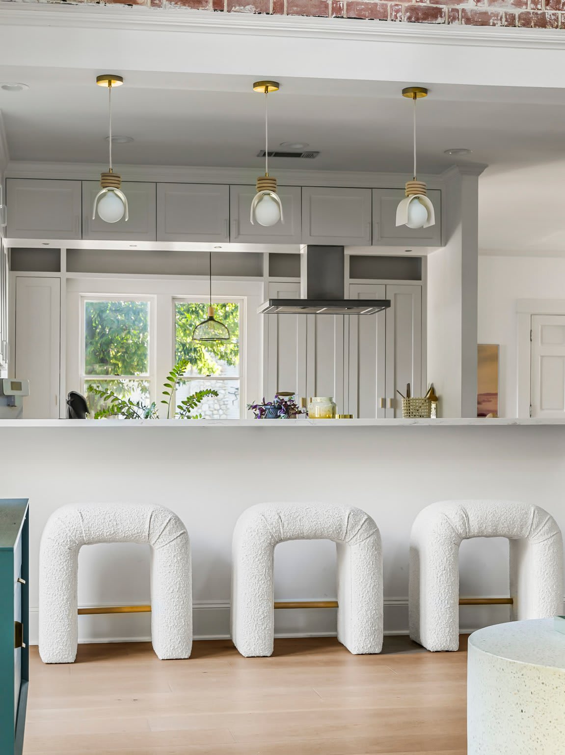 Kitchen with pendant lighting and arched barstools at 1500 Northwood Rd, Pemberton Heights, Austin. Renovation by McWalters Collaborative.