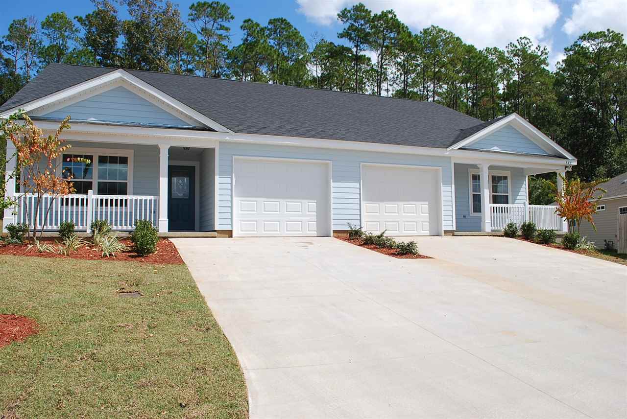 A two-story home featuring two garages and a spacious driveway.