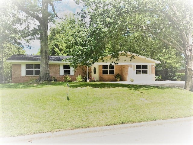 A brick home surrounded by a spacious yard and trees, showcasing a serene and inviting outdoor environment.