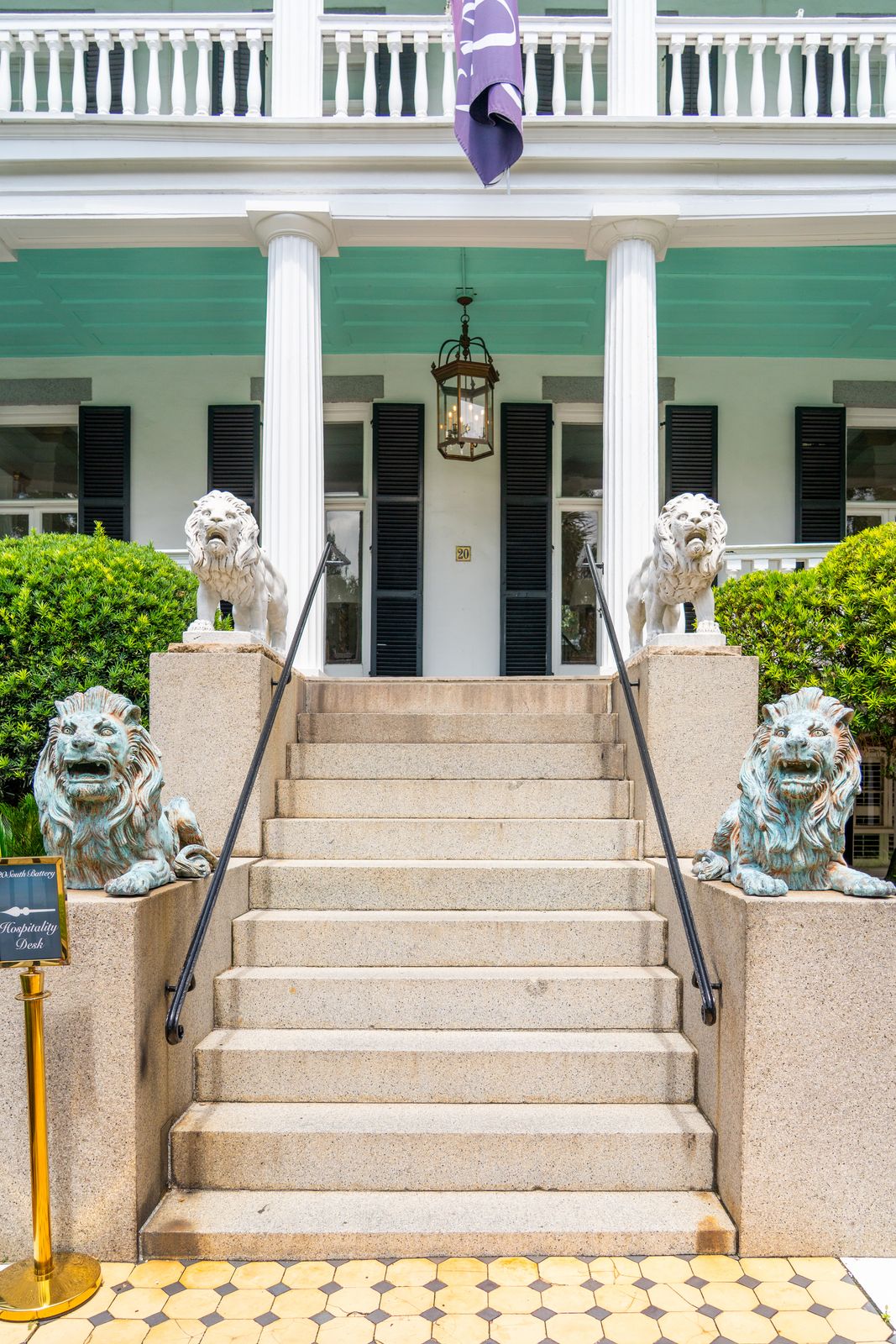 20 South Battery entrance with stone steps, white columns, and lion statues.