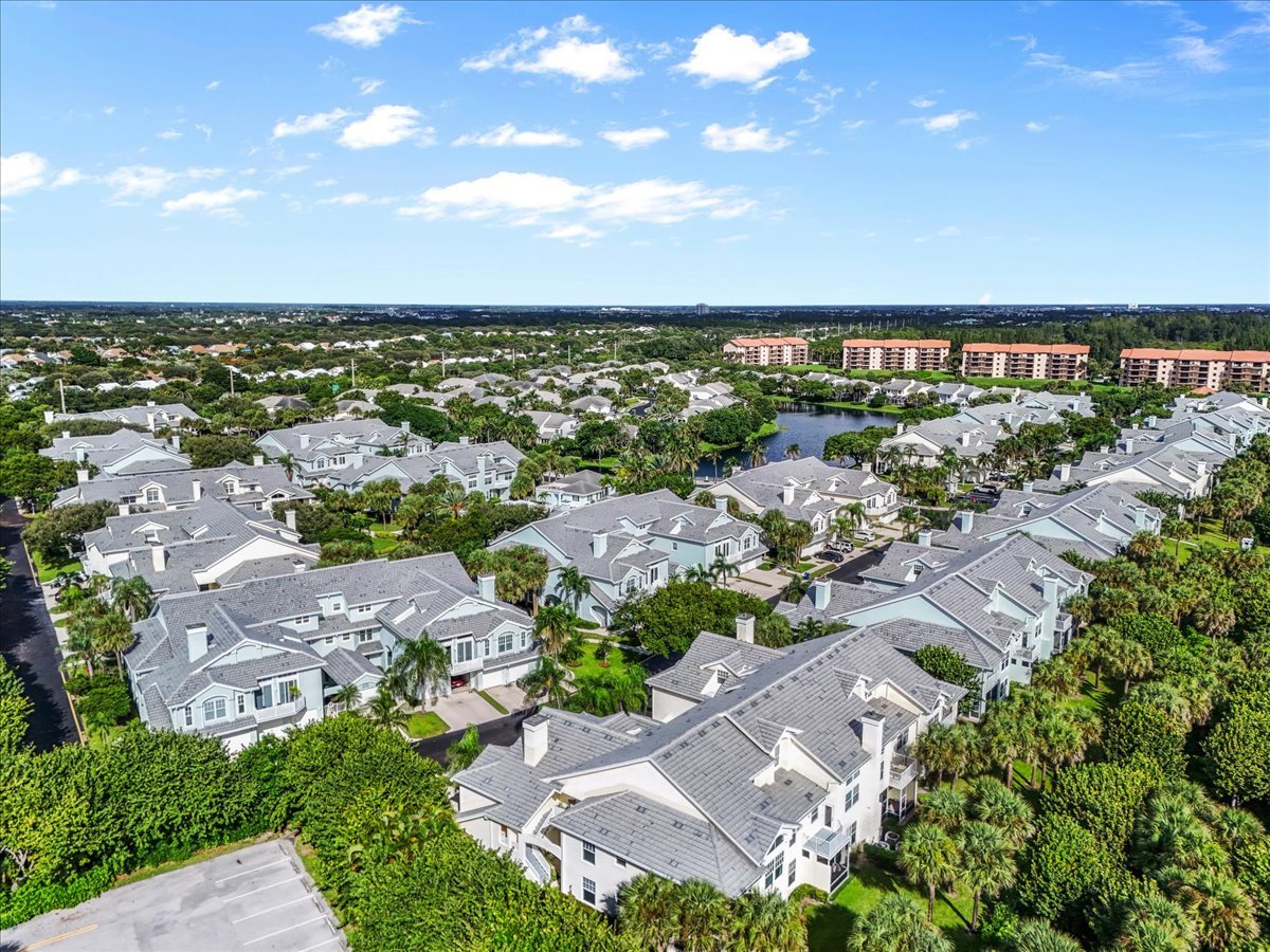 Aerial view of Sea Colony homes around a lake, with condominium buildings in the distance.