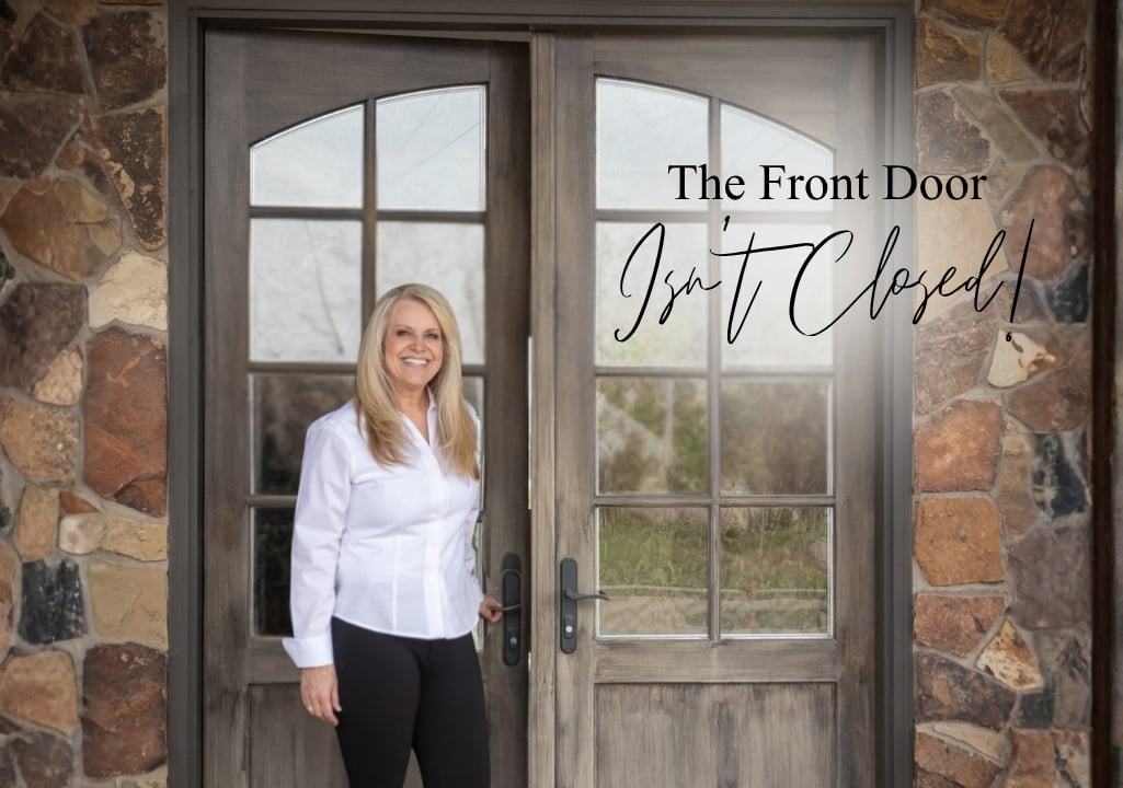 Sharla Ellis standing at a front door during National Homeownership Month, discussing mortgage options for self-employed and non-traditional borrowers.