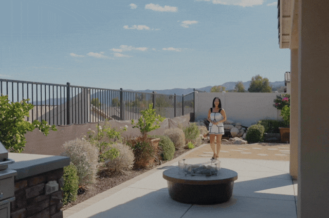 Patio with a round fire pit, landscaped garden, and distant mountain views.