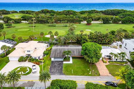 Aerial view of East Boca homes beside a golf course and the Atlantic Ocean.