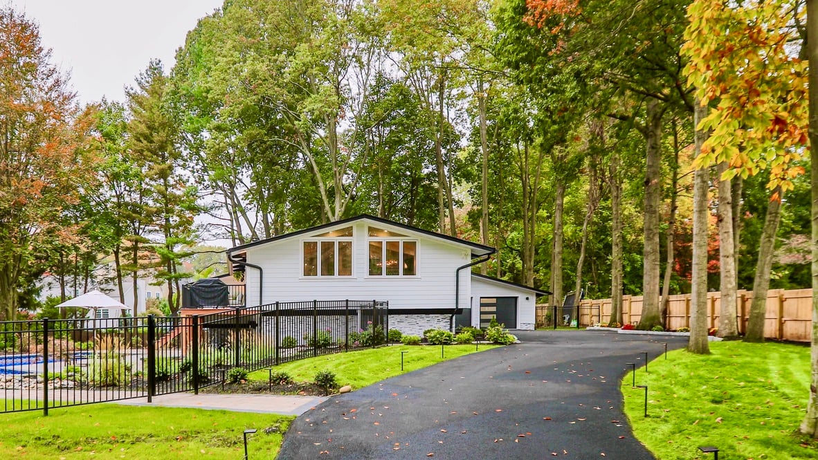 norwood-nj white modern house exterior with black roof trim and manicured lawn
