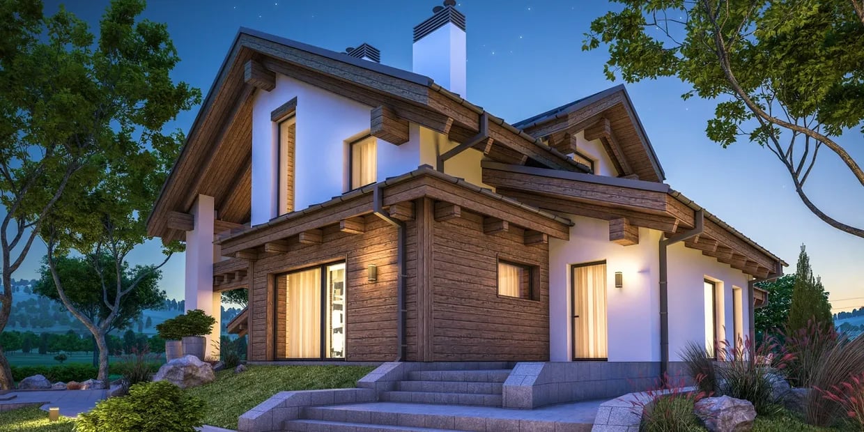 Modern timber-and-white chalet with broad stone steps and glowing windows at dusk.