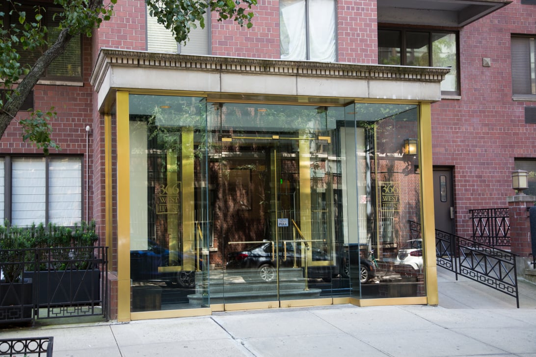 Entrance to 366 West 11th Street, with a glass lobby framed in gold-colored metal and red brick.