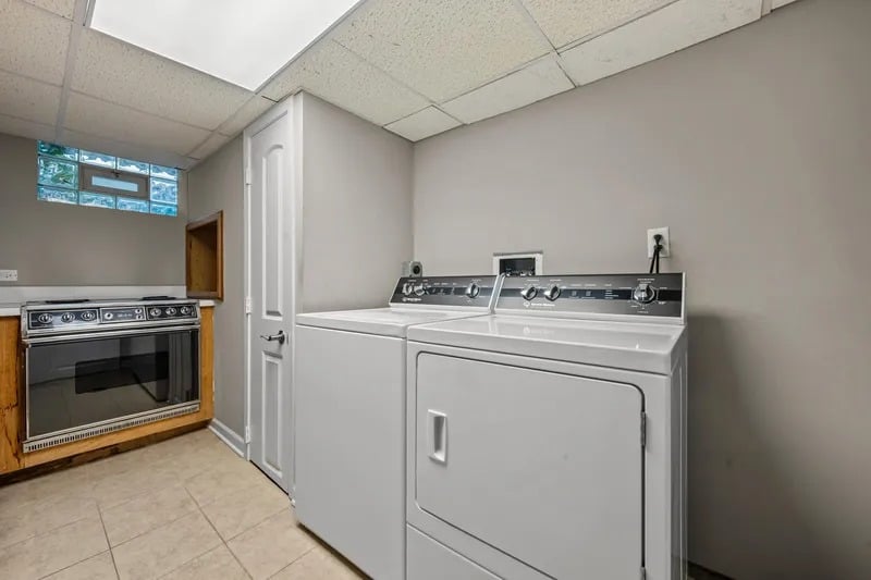 Laundry room with a washer and dryer beside an electric range.