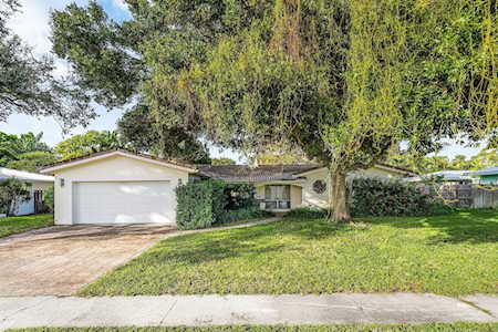 Single-story home with a two-car garage and a large shade tree across the front lawn.