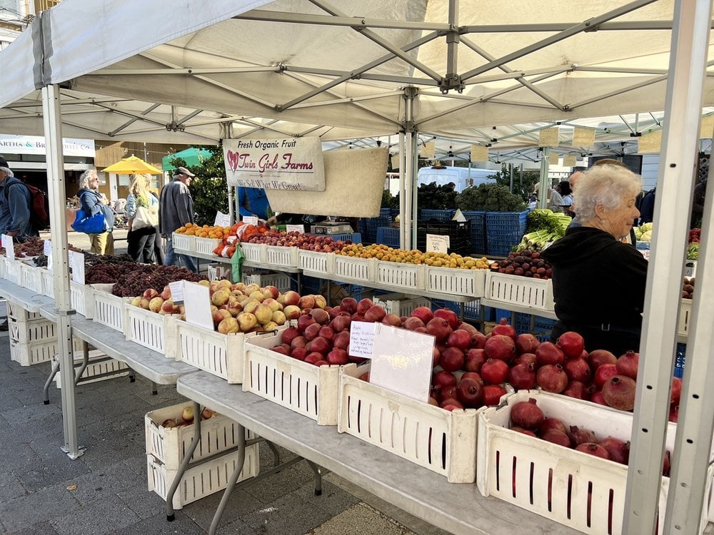 Vendors selling fresh produce and artisanal goods at Noe Valley Farmers' Market on a sunny weekend morning.