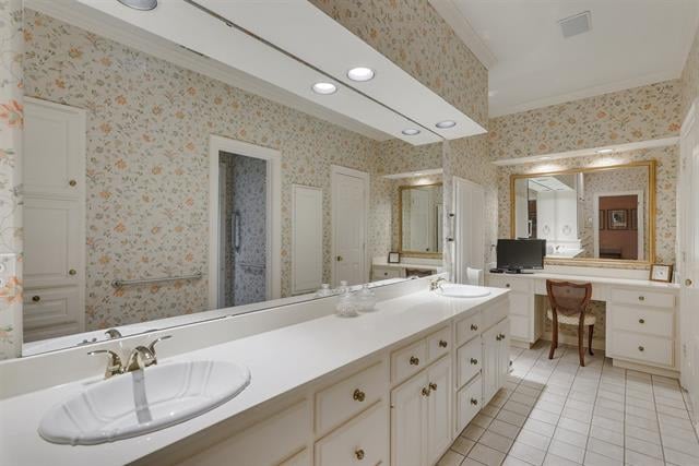 Bathroom with a long double vanity, mirrored wall, floral wallpaper, and tiled floor.