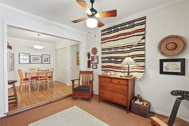 Furnished room with a wooden dresser and striped wall hanging, opening to a dining area.
