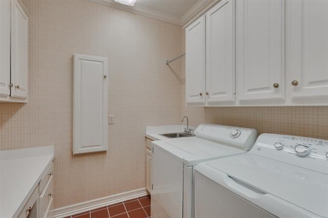 Laundry room with white washer and dryer, utility sink, and wall cabinets.