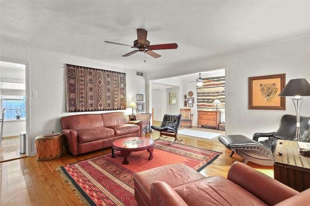 Living room with leather seating, hardwood floors, and a red patterned rug.