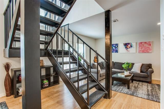 Furnished living area with an open-riser staircase, skylight, and gray sofa.