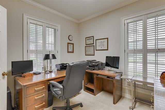 Home office with L-shaped wooden desks, computer equipment, and plantation-shuttered windows.