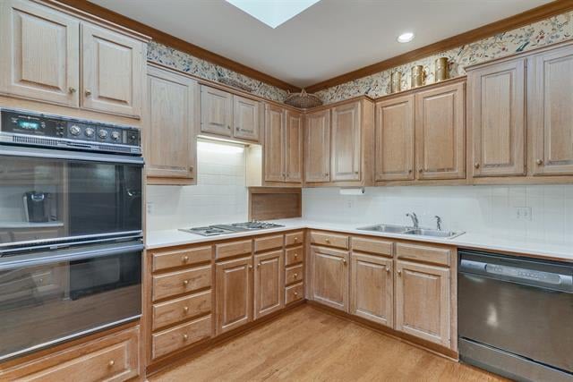 Kitchen with light wood cabinets, a built-in double oven, cooktop, and stainless-steel dishwasher.