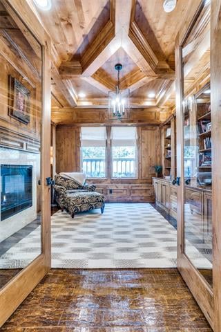 Wood-paneled library with a vaulted ceiling, built-in bookshelves, fireplace, and patterned rug.