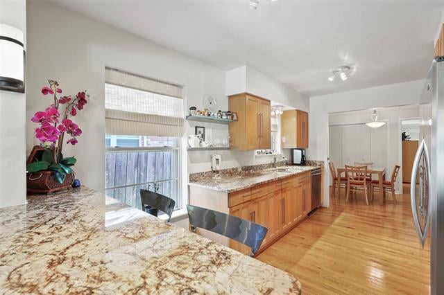 Kitchen with granite countertops, wood cabinets, and an adjoining dining area.