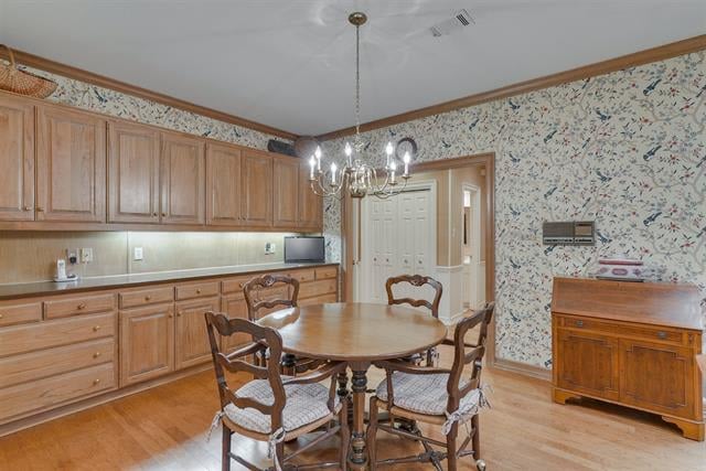 Dining room with a round wooden table, built-in cabinetry, patterned wallpaper, and chandelier.