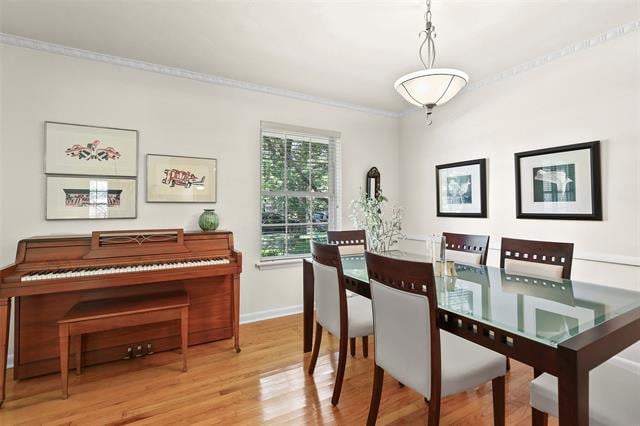 Dining room with a glass-top table, upholstered chairs, and a wooden upright piano.