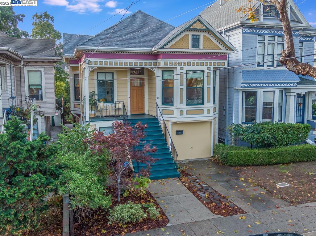 Victorian-style house with colorful trim, a bay window, and teal front stairs.