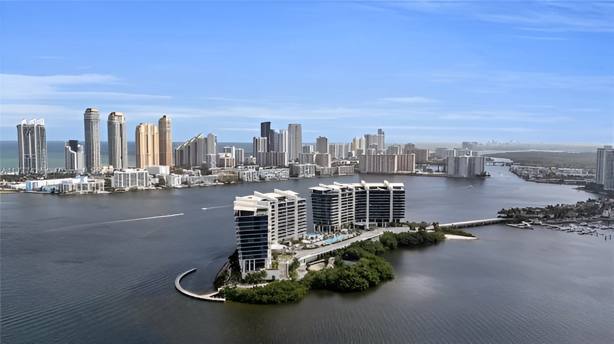Privé Island waterfront towers on a landscaped island, with water and a distant city skyline.