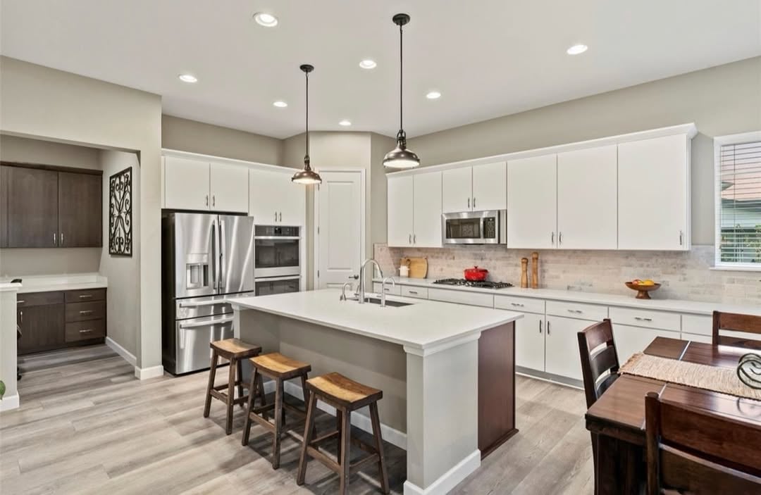 Gourmet kitchen at 2896 Keepsake Way Castle Rock featuring large quartz island, double ovens, walk-in pantry and open living flow in The Meadows home.