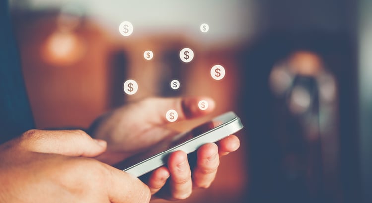 Hands using a smartphone with floating dollar signs.
